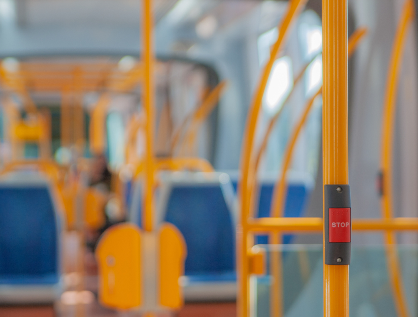 Bus interior blurred with red "stop" button in foreground