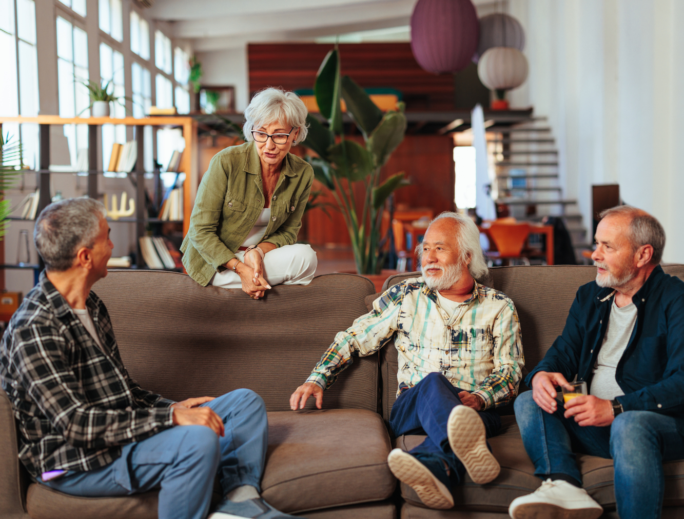 Support group of four people sat talking together on sofa