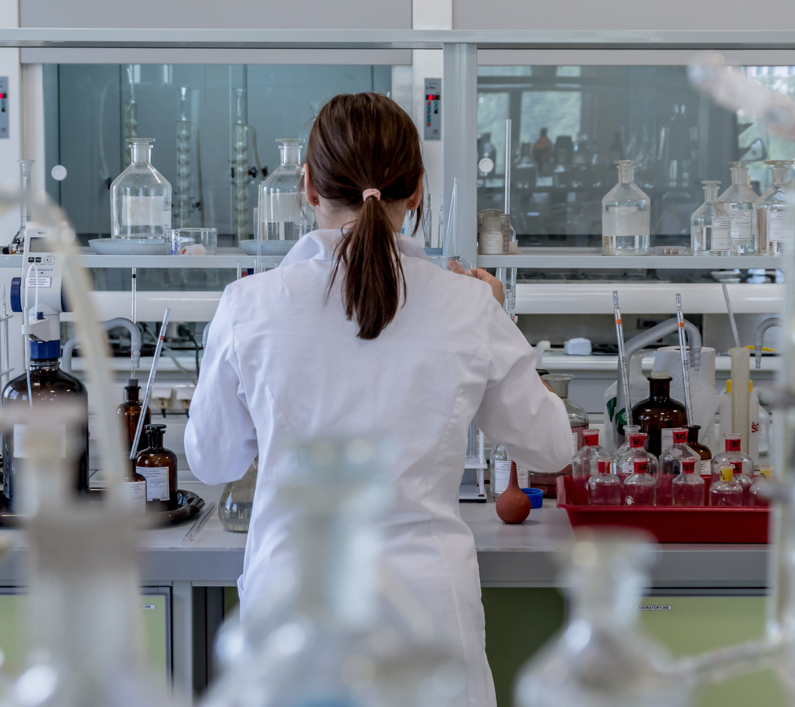 scientist in white lab coat conducting lab experiments