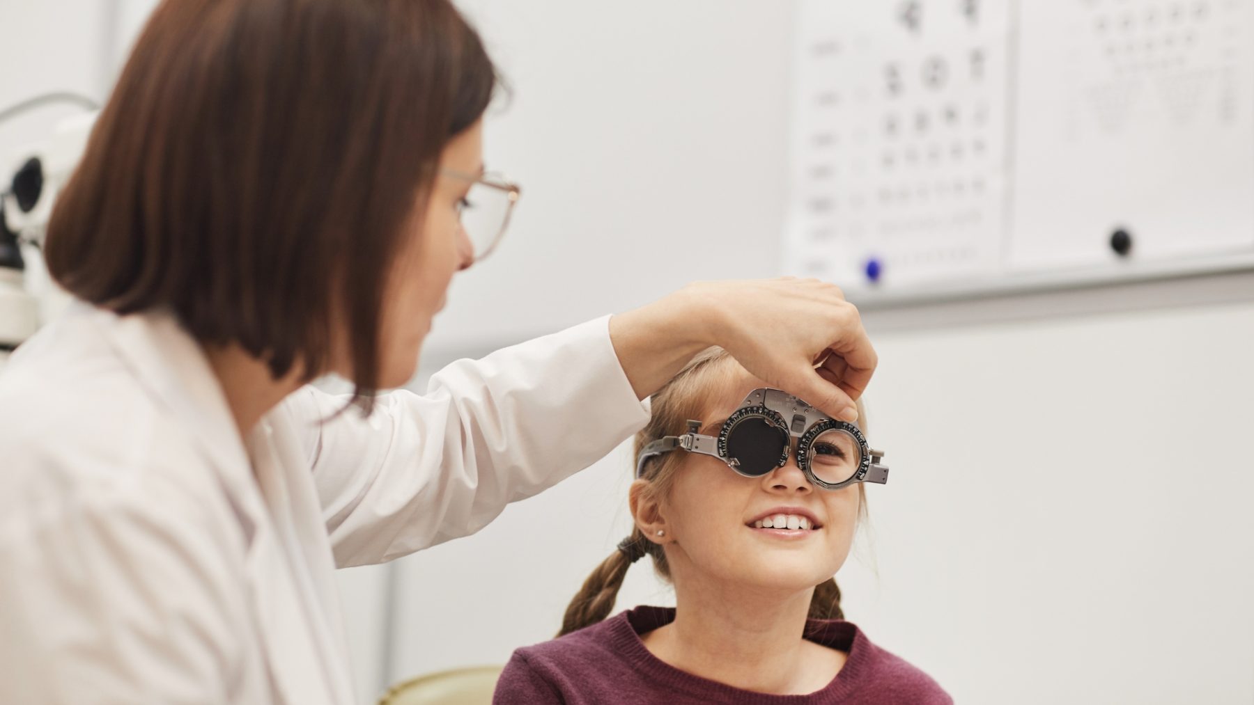 Young girl getting her eyes tested by an optrician