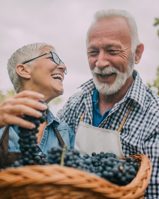 Two people smiling and enjoying time together outdoors.