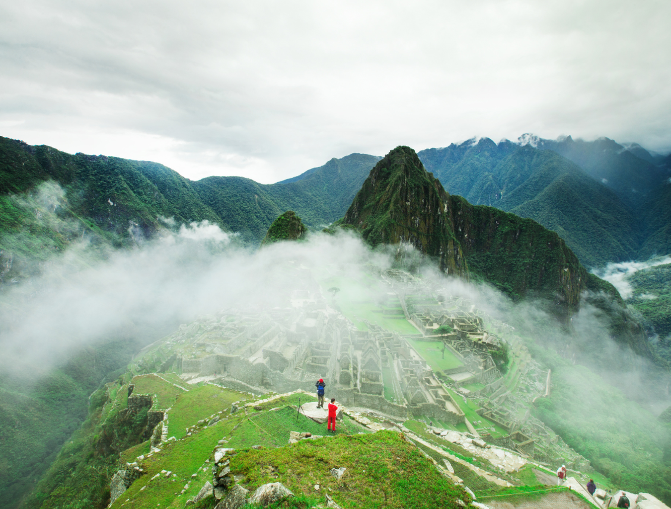 People on summit of Machu Picchu on cloudy day