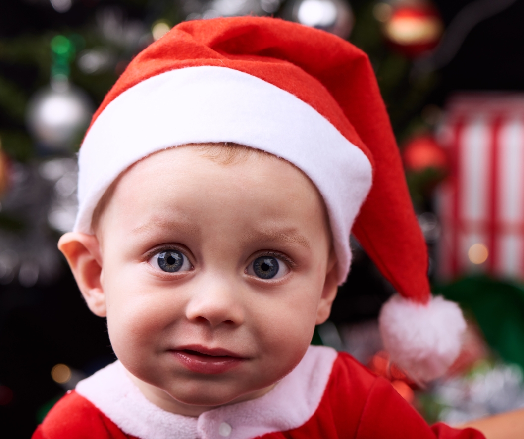 Small child wearing a red Santa hat and outfit