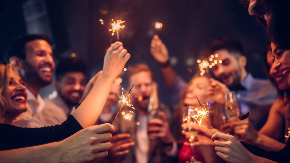 Group of people celebrating and holding up sparklers