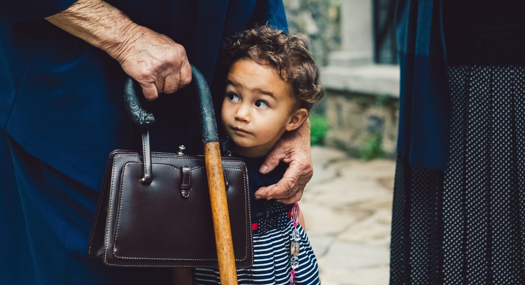 Child holding adult's arm, curious expression. 40 years of visionary science Charity Report back page