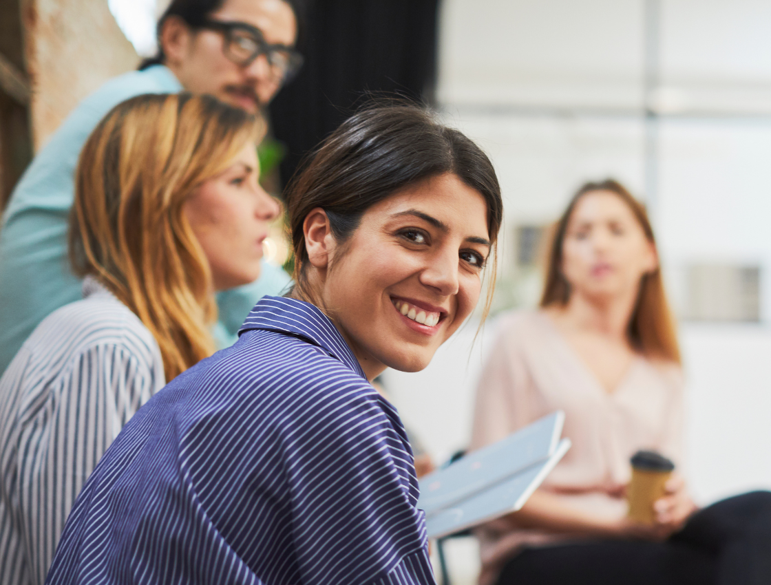 Team of people, one person turned to smile at camera