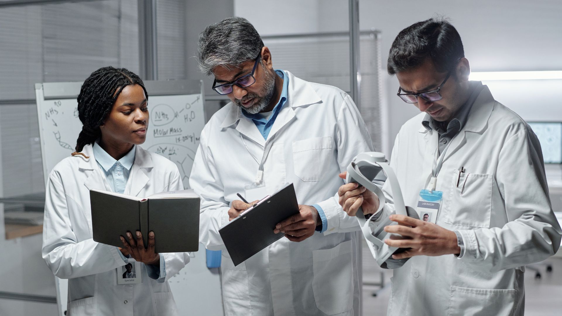 Three clinicians having a discussion looking at papers