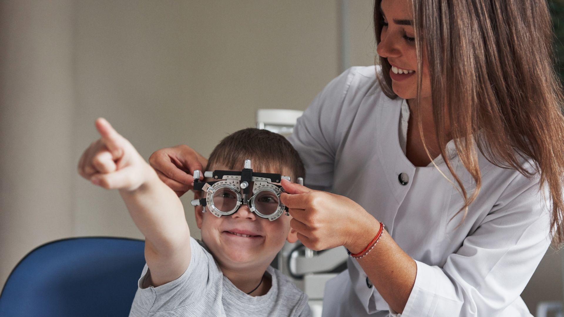 A young boy getting his eyes tested by an optrician